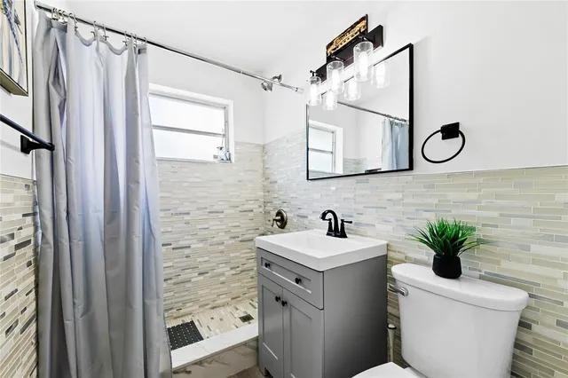 a bathroom with a toilet a sink and a mirror