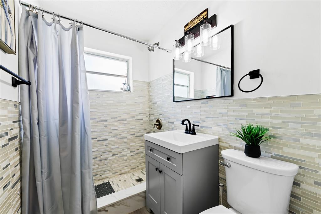 1357 Southwest 4th Terrace Pompano Beach, FL 33060 - Photo 12 of 25 a bathroom with a toilet a sink and a mirror