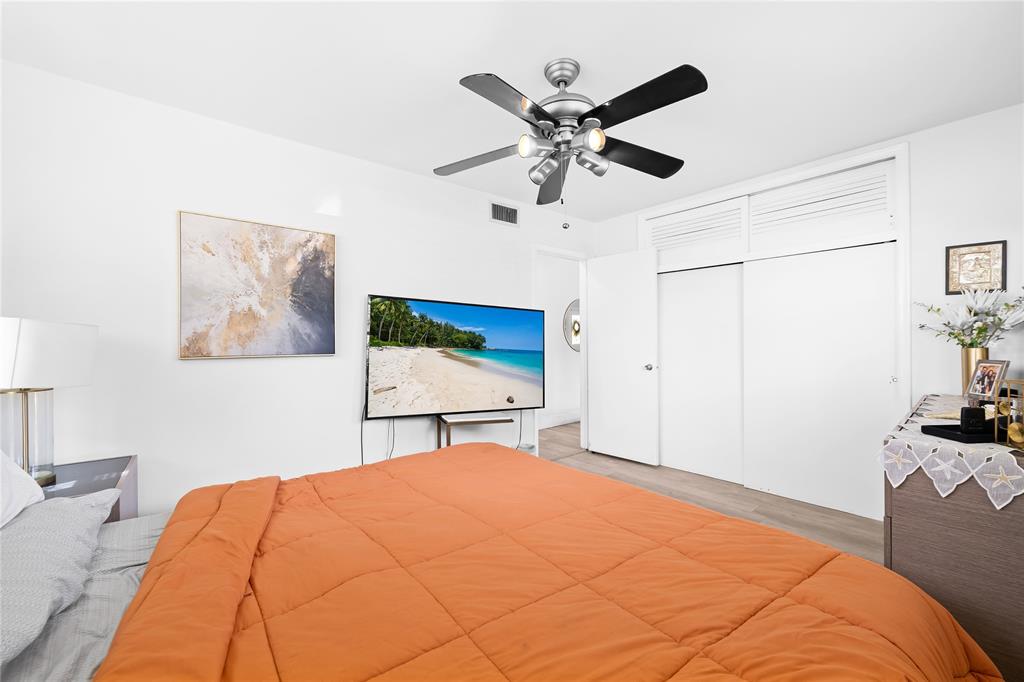 1357 Southwest 4th Terrace Pompano Beach, FL 33060 - Photo 14 of 25 a bedroom with a large bed and a chandelier