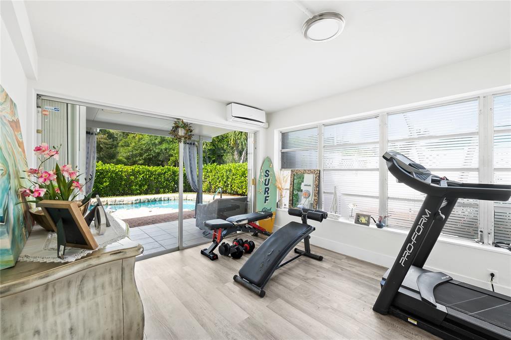 1357 Southwest 4th Terrace Pompano Beach, FL 33060 - Photo 16 of 25 a living room with furniture gym equipment and a large window