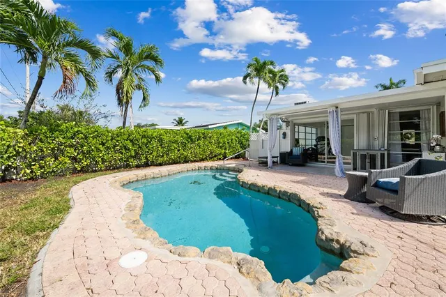 a swimming pool with outdoor seating and plants