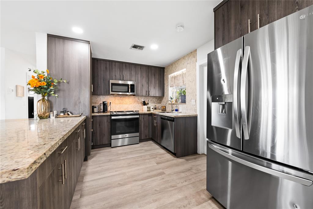 1357 Southwest 4th Terrace Pompano Beach, FL 33060 - Photo 3 of 25 a kitchen with stainless steel appliances granite countertop a refrigerator a stove and a sink