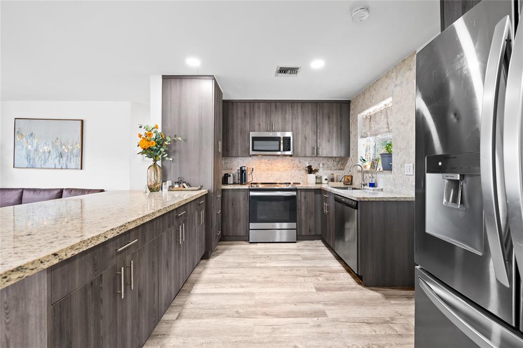 1357 Southwest 4th Terrace Pompano Beach, FL 33060 - Photo 4 of 25 a large kitchen with stainless steel appliances kitchen island a sink stove and refrigerator