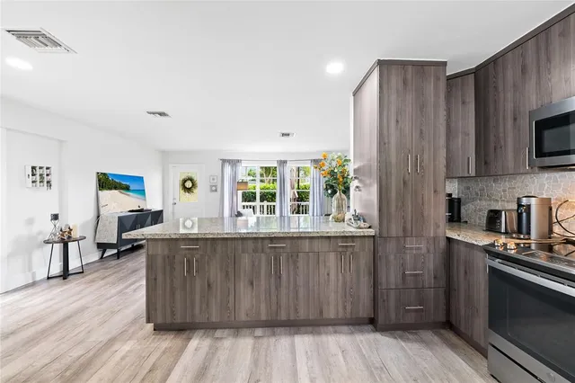 a kitchen with stainless steel appliances wooden floors and wooden cabinets