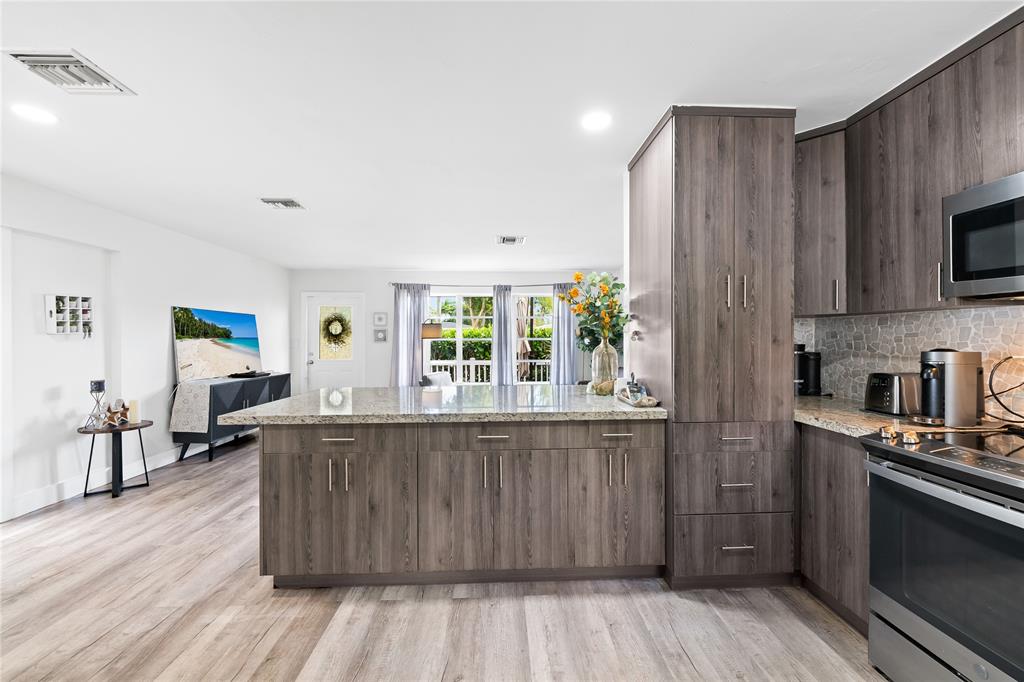1357 Southwest 4th Terrace Pompano Beach, FL 33060 - Photo 8 of 25 a kitchen with stainless steel appliances wooden floors and wooden cabinets