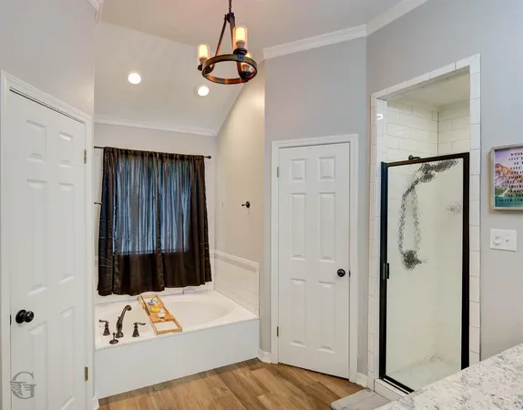 a view of a bedroom with a bed and wooden floor
