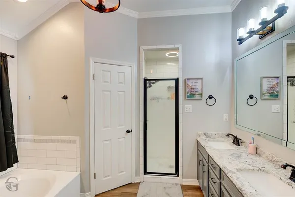 a bathroom with a granite countertop sink a mirror and a bathtub