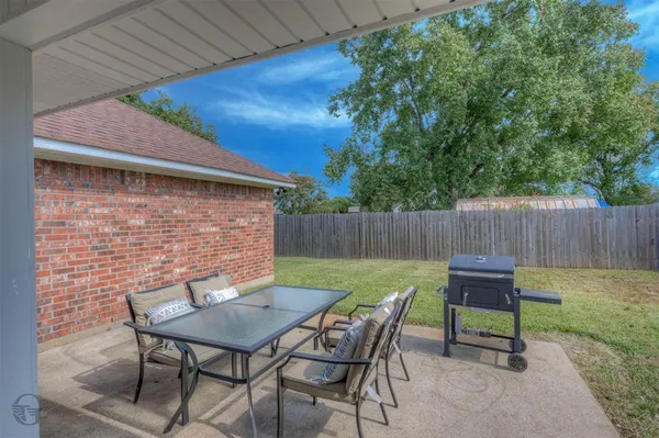a backyard of a house with table and chairs