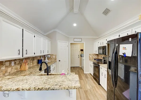 a kitchen with stainless steel appliances granite countertop a refrigerator stove and oven