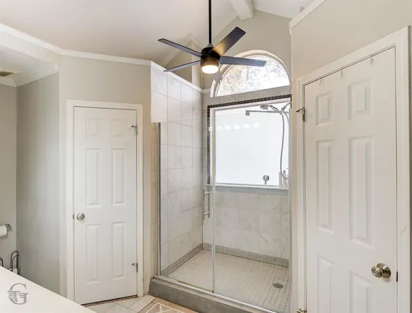 a bathroom with a glass shower door and a window