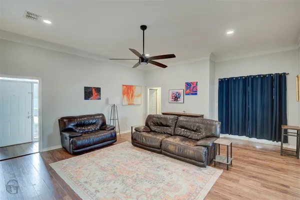 a living room with furniture and a wooden floor