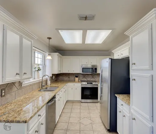 a large kitchen with cabinets appliances and a counter space