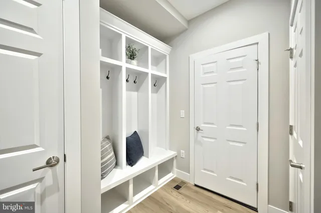 a view of a hallway with wooden floor and a potted plant
