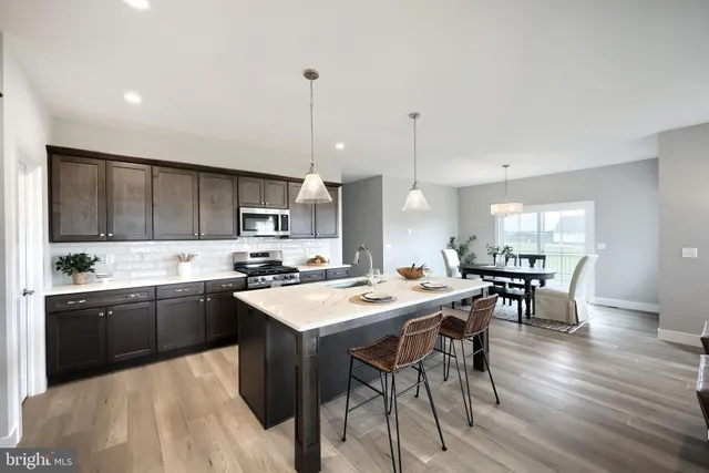 a kitchen with a sink a microwave a stove and cabinets