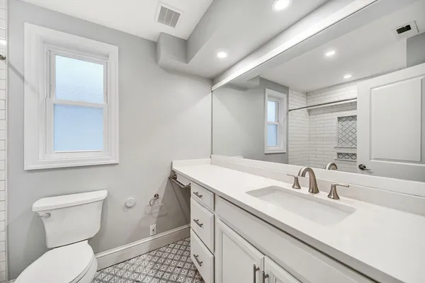 a bathroom with a sink a toilet and a mirror