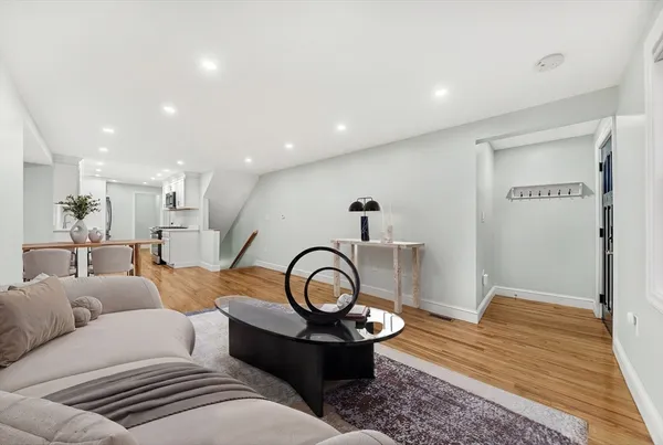 a living room with furniture and a wooden floor