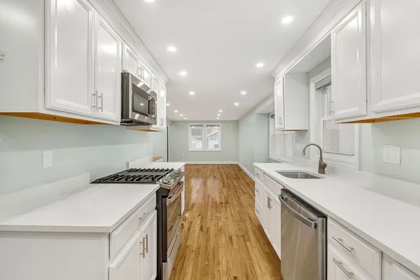 a kitchen with a sink a stove and cabinets