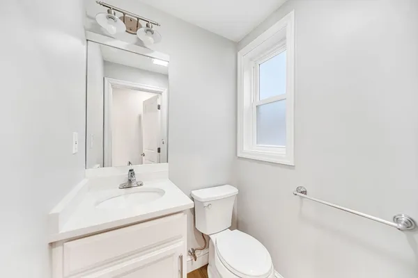 a bathroom with a sink a toilet and mirror