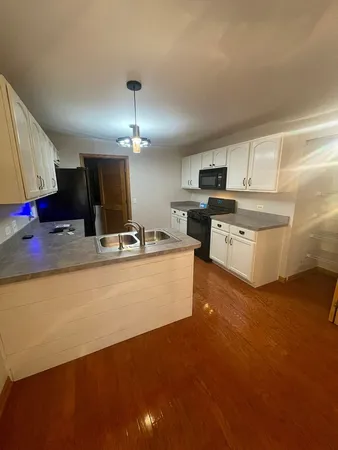 a large kitchen with kitchen island a sink stainless steel appliances and cabinets