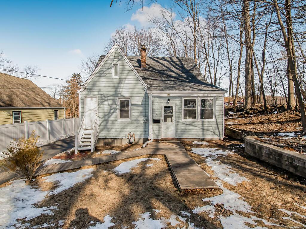 View of front of home with entry steps, a chimney, and fence