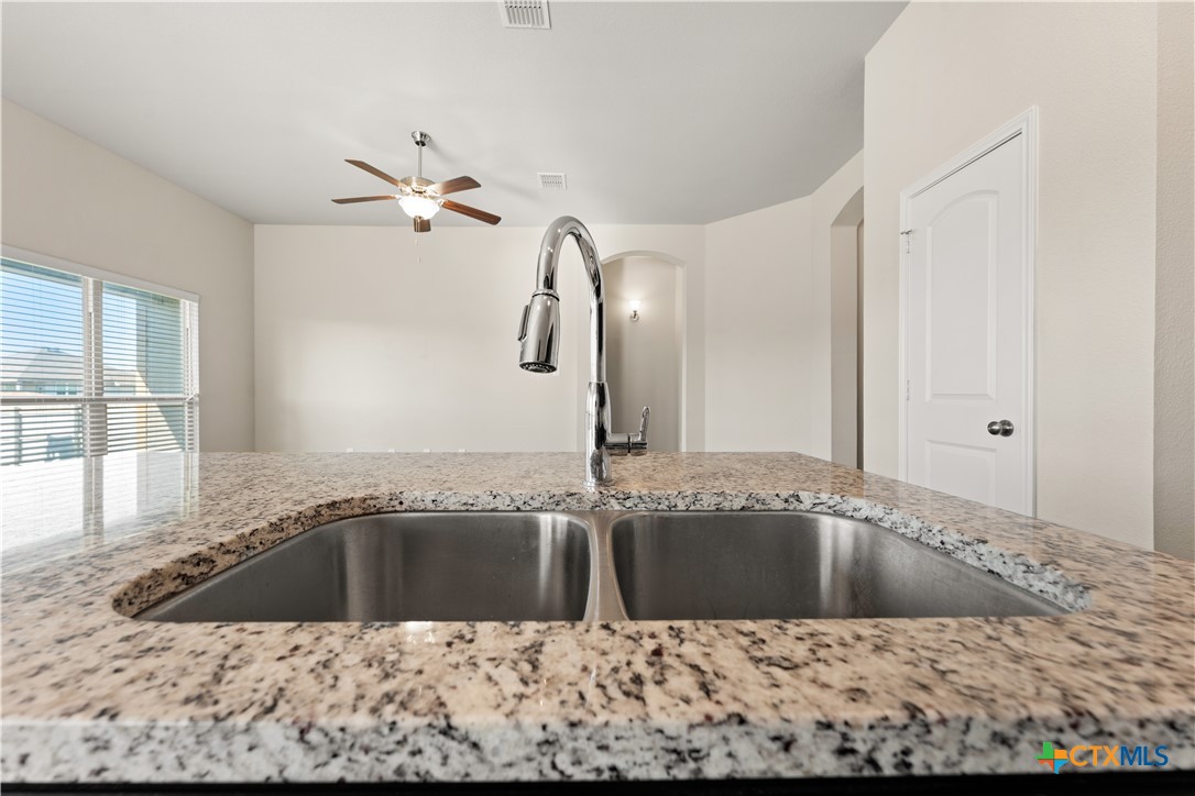 4124 Riata Ranch Road Waco, TX 76705 - Photo 11 of 26 a bathroom with a granite countertop sink a mirror and bathtub