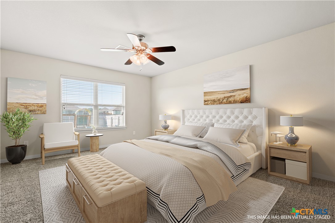 4124 Riata Ranch Road Waco, TX 76705 - Photo 14 of 26 a bedroom with a large bed and a chandelier