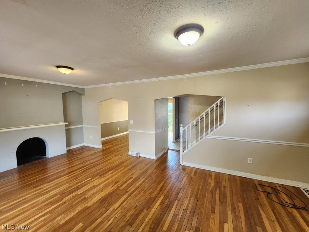 3602 Silsby Road University Heights, OH 44118 - Photo 5 of 19 Unfurnished room featuring a textured ceiling, hardwood flooring, and ornamental molding