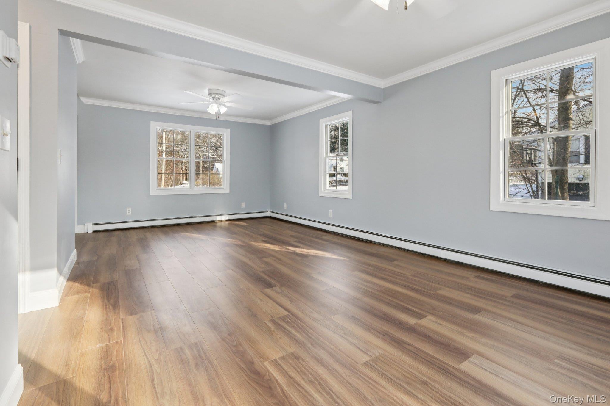 95 Smithtown Road Fishkill, NY 12524 - Photo 11 of 50 Spare room with a ceiling fan, crown molding, a baseboard heating unit, waterproof laminate floors, and natural light