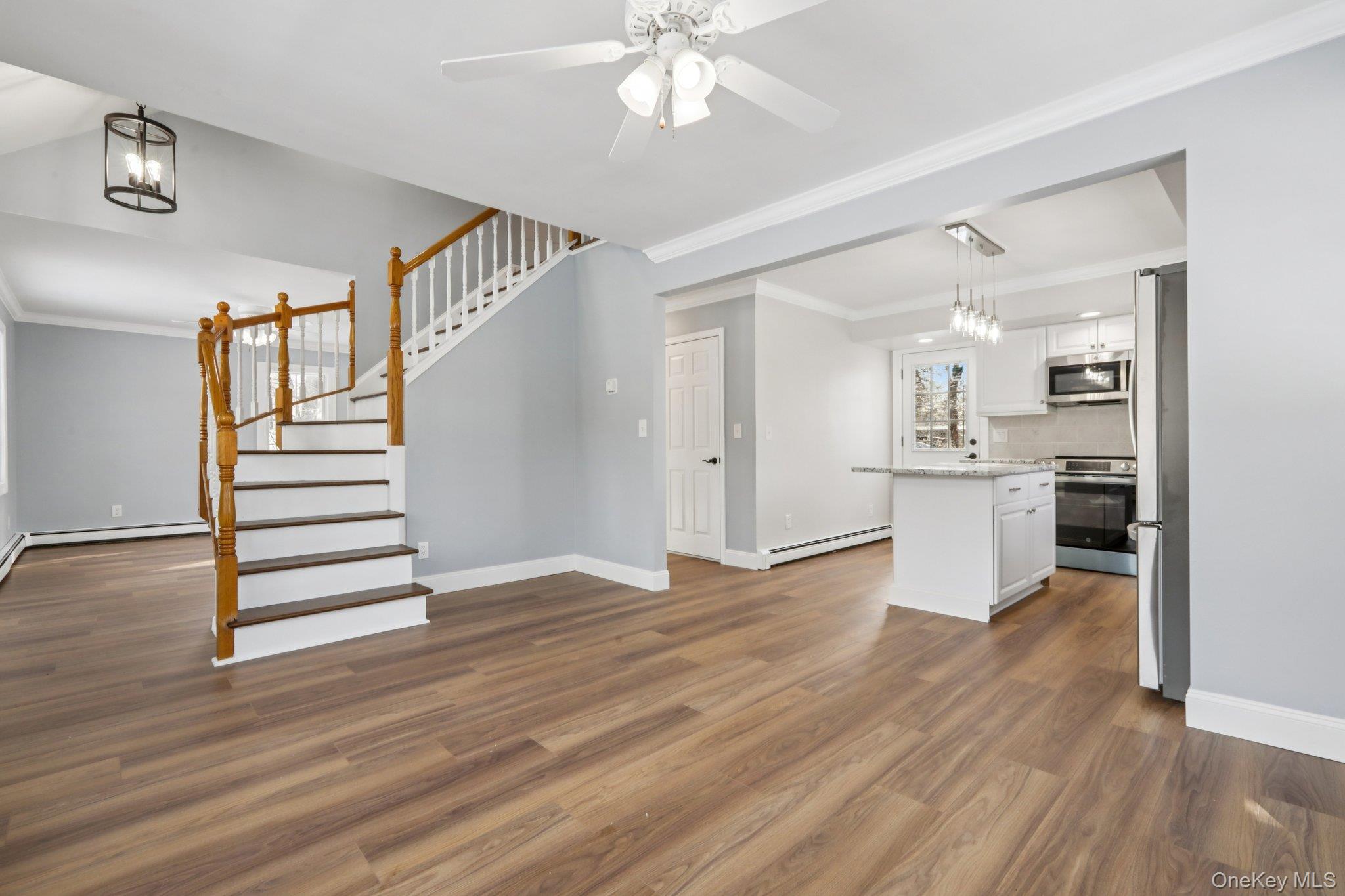 95 Smithtown Road Fishkill, NY 12524 - Photo 13 of 50 Dining room with crown molding, waterproof laminate flooring, baseboard heating, stairway, and ceiling fan