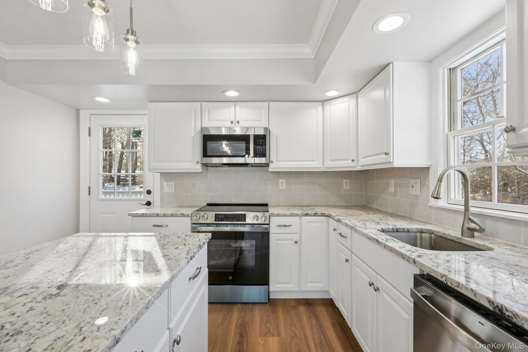 95 Smithtown Road Fishkill, NY 12524 - Photo 17 of 50 Kitchen featuring stainless steel appliances, white cabinets, light stone counters, decorative backsplash, and pendant lighting