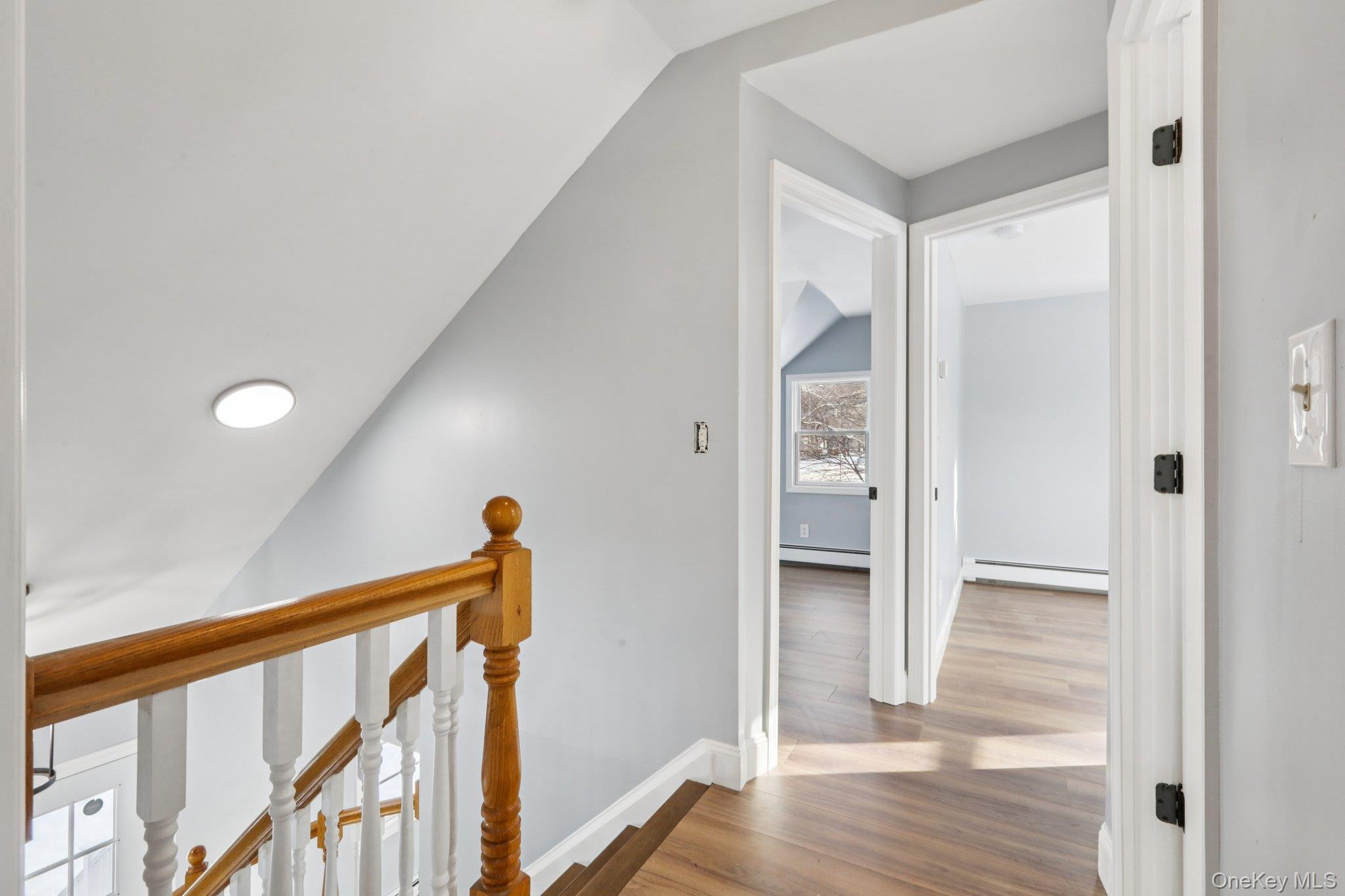 95 Smithtown Road Fishkill, NY 12524 - Photo 22 of 50 Hall featuring vaulted ceiling, an upstairs landing, waterproof laminate floors, and a baseboard heating unit
