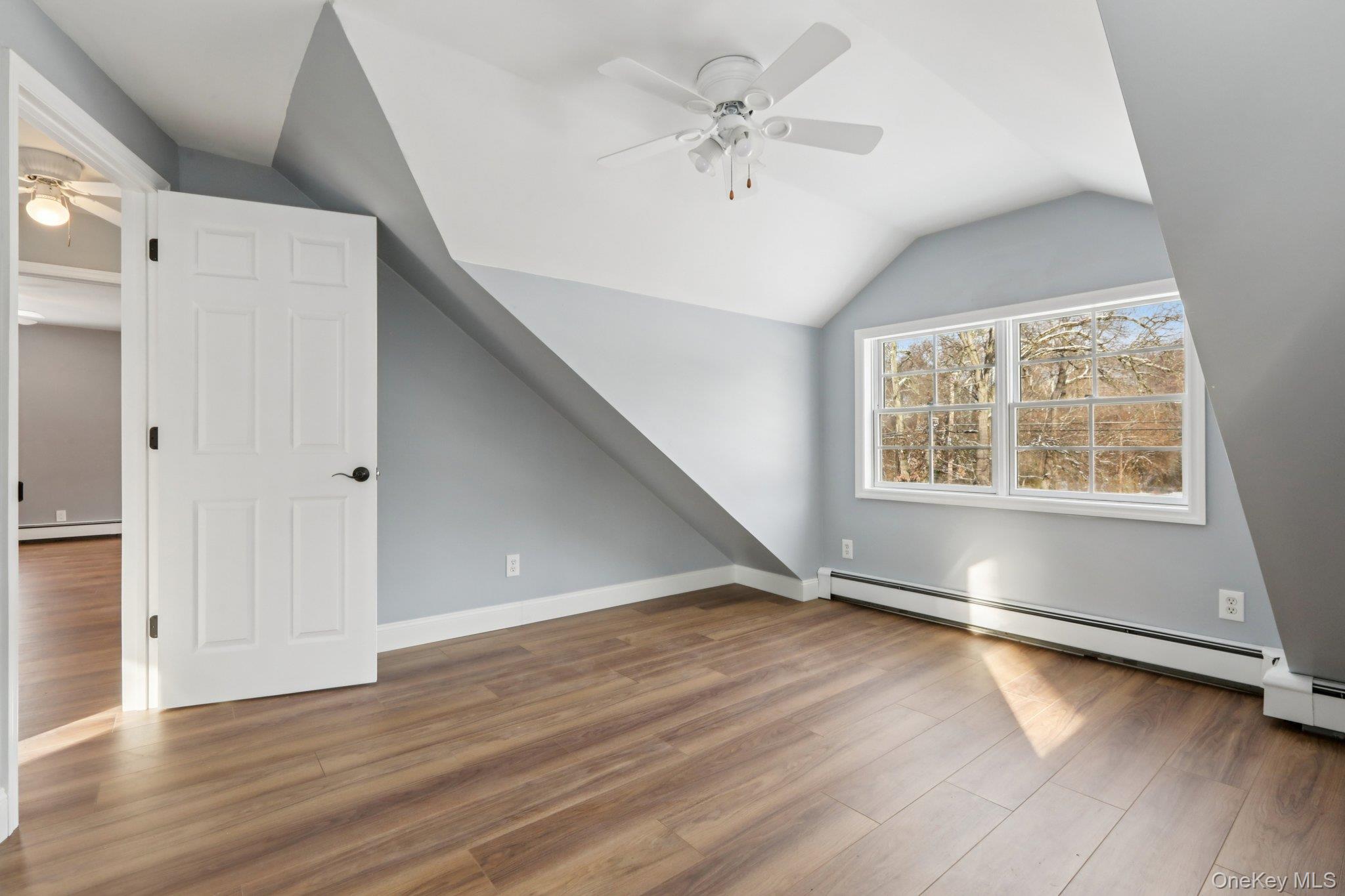 95 Smithtown Road Fishkill, NY 12524 - Photo 24 of 50 bedroom 1 featuring a ceiling fan, waterproof laminate floors, lofted ceiling, and a baseboard heating unit