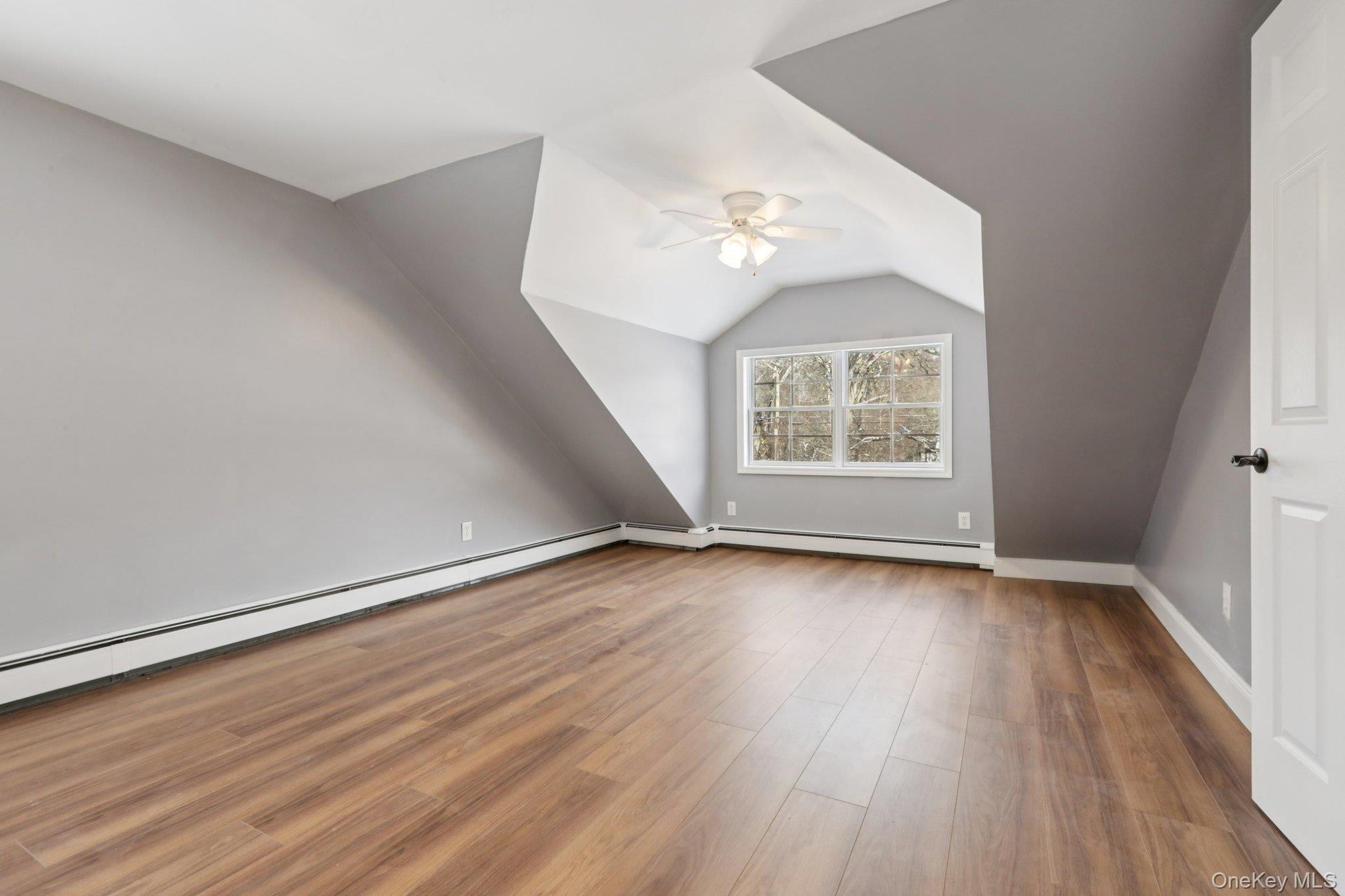 95 Smithtown Road Fishkill, NY 12524 - Photo 30 of 50 Waterproof laminate floors, lofted ceiling, a baseboard heating unit, and a ceiling fan