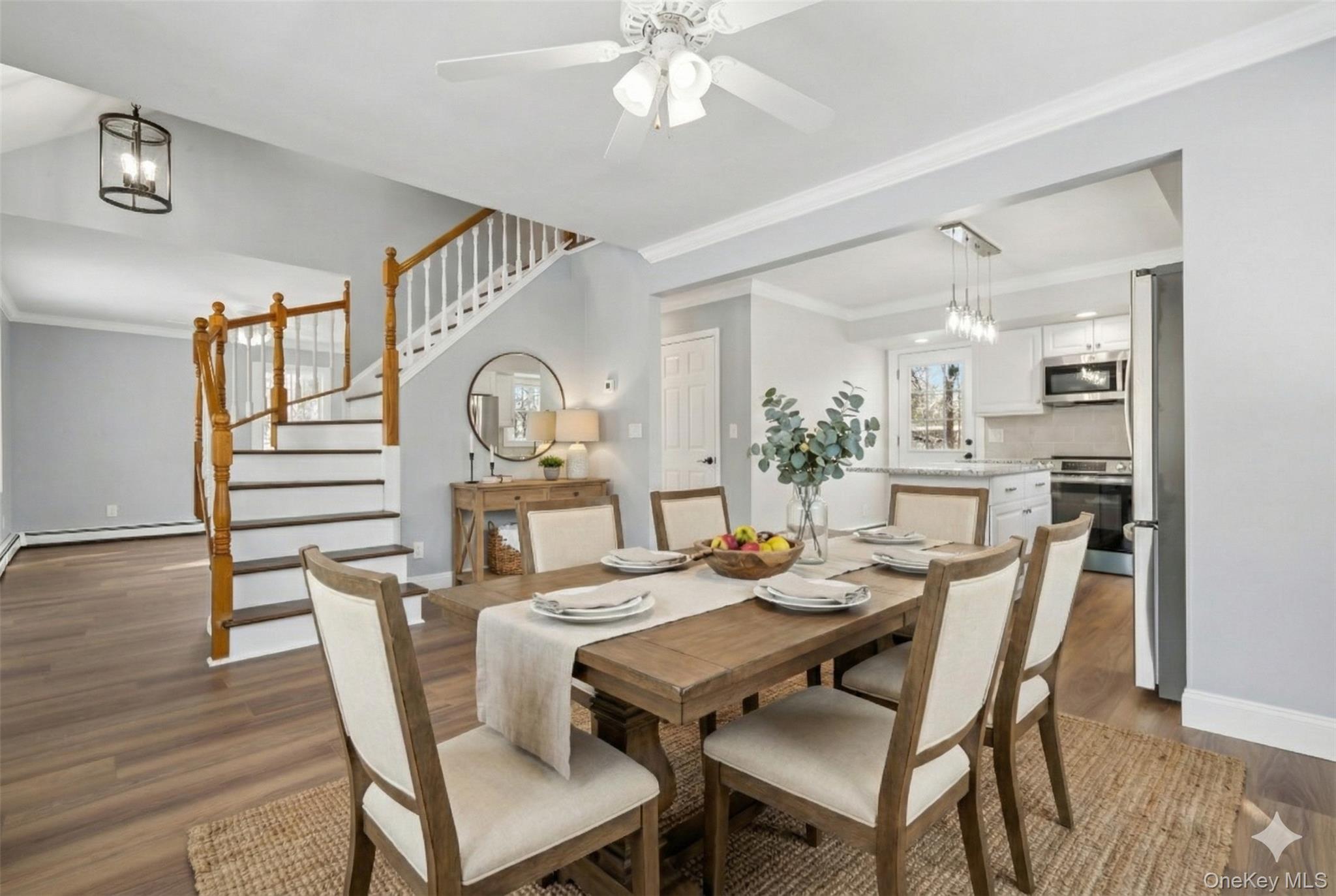 95 Smithtown Road Fishkill, NY 12524 - Photo 48 of 50 Dining space featuring crown molding, dark wood-type flooring, stairway, ceiling fan, and a chandelier