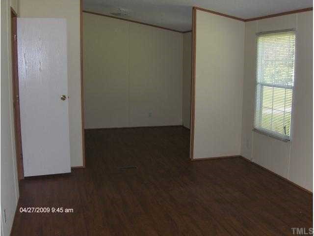 1392 Mill Creek Road Roxboro, NC 27574 - Photo 4 of 4 a view of an empty room with wooden floor and a window