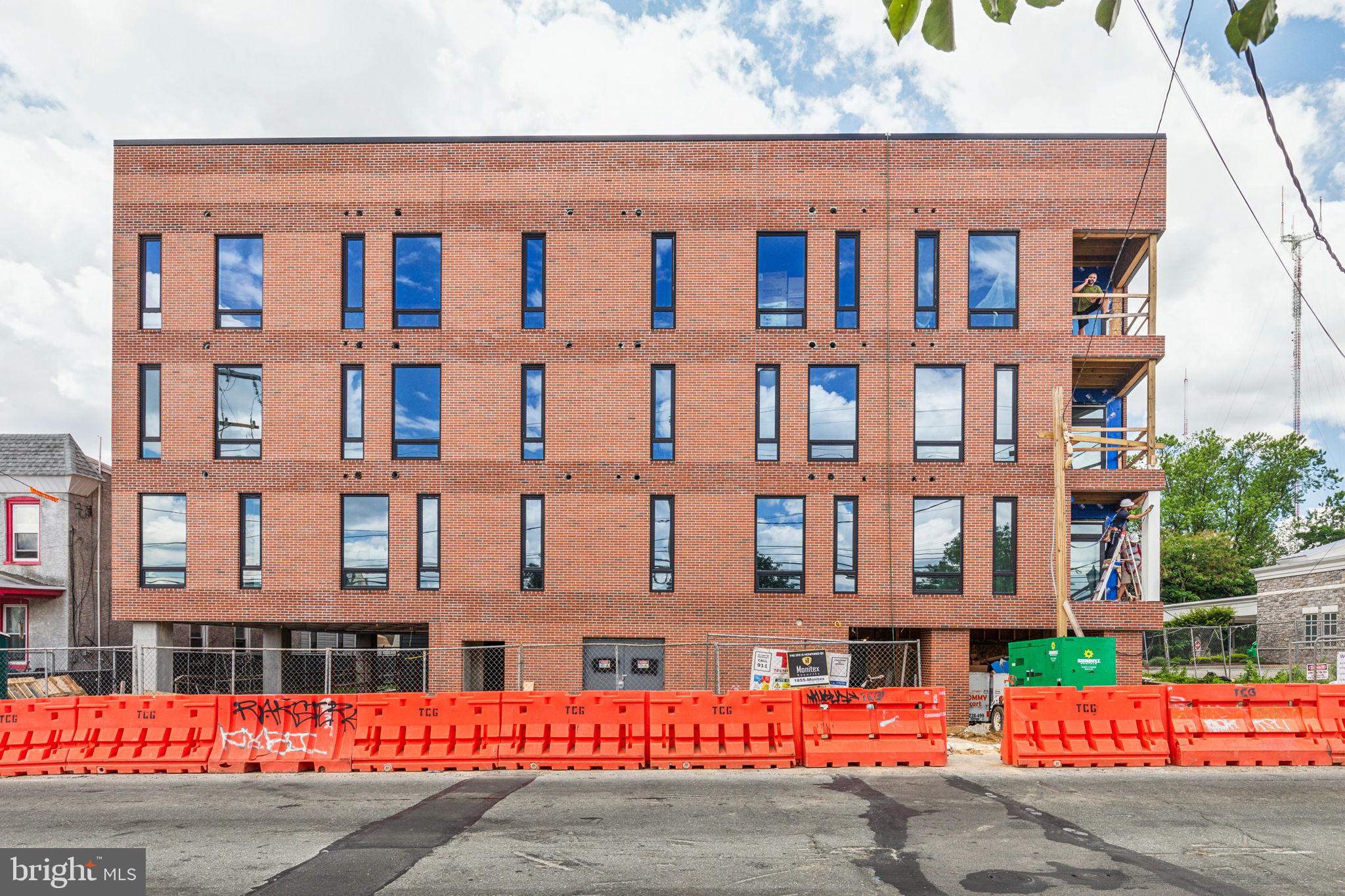 6910 Ridge Avenue, Unit 405 Philadelphia, PA 19128 - Photo 20 of 21 a front view of a residential apartment building with a yard