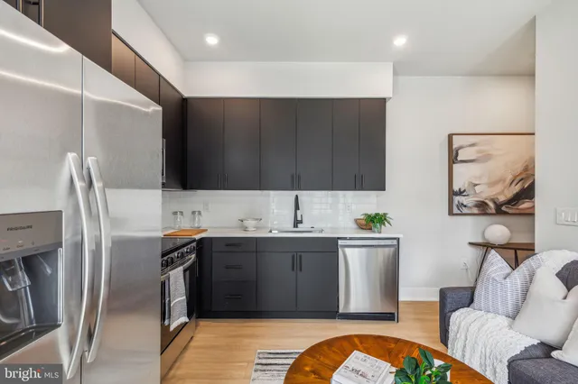 a kitchen with stainless steel appliances granite countertop a sink a stove and refrigerator