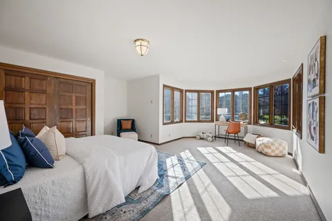 a spacious bedroom with a bed and wooden floor