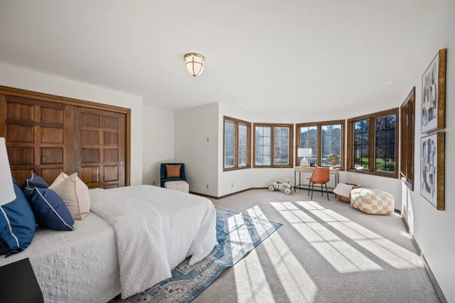 a spacious bedroom with a bed and wooden floor