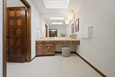 a spacious bathroom with a double vanity sink a mirror and shower