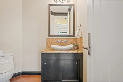 a bathroom with a sink a toilet and mirror