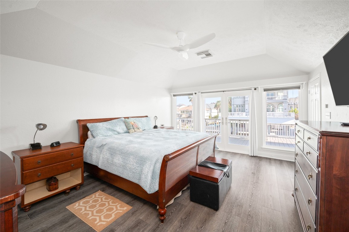 242 Isles End Road Tiki Island, TX 77554 - Photo 18 of 50 The grand Primary Suite overlooks the picturesque canal and features French doors that open to a private deck, creating a peaceful retreat with water views and coastal breezes.