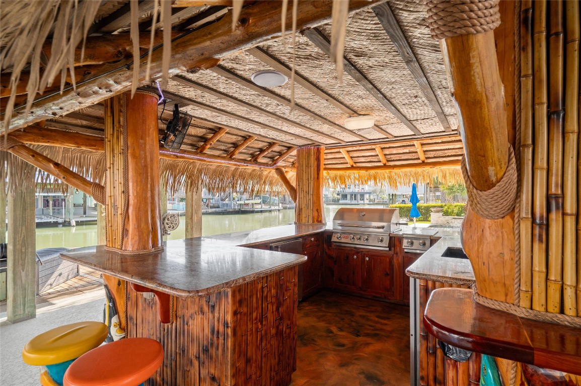 242 Isles End Road Tiki Island, TX 77554 - Photo 43 of 50 The Tiki Bar features a sink, 30 inch grill, double side burner, ice maker, two fridges, custom stools, and plenty of storage for entertaining supplies.