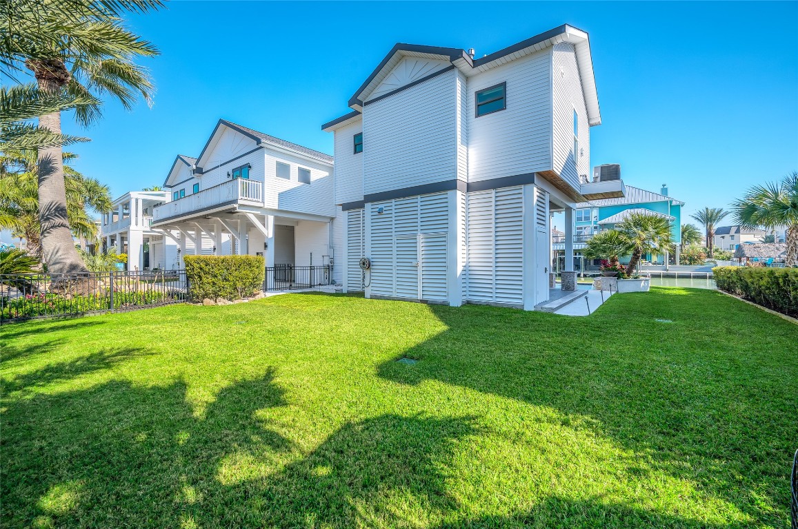242 Isles End Road Tiki Island, TX 77554 - Photo 48 of 50 The fully fenced yard includes a separate turf dog run and plenty of space for recreation, outdoor play, all with convenient access to the pool and canal beyond.