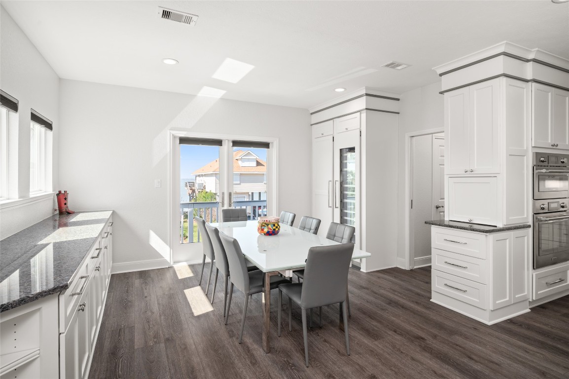 242 Isles End Road Tiki Island, TX 77554 - Photo 8 of 50 The spacious dining area accommodates a large table and is complemented by loads of natural light and views of the greenspace and Jones bay. Note the wine fridge and appliance garage, as well as storage for China, flatware, and entertaining linens and dishware.