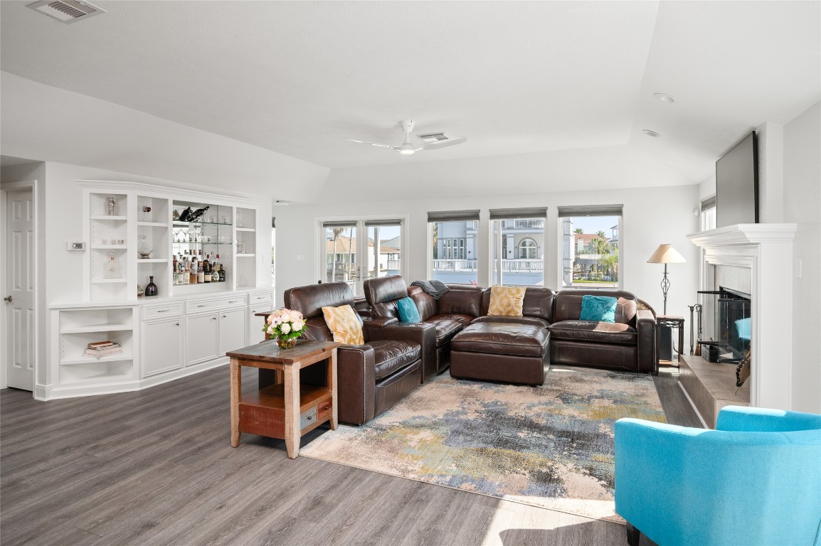 242 Isles End Road Tiki Island, TX 77554 - Photo 10 of 50 This cozy den/living space will be an every day favorite. You can enjoy the natural sunlight, or close the blinds for a cozy ambiance. The bar and built-ins are ideally situated for entertaining and displaying collectibles.