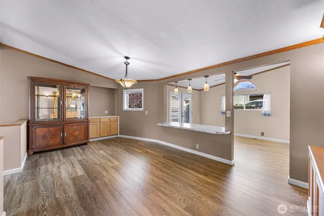 a view of an empty room with window and wooden floor