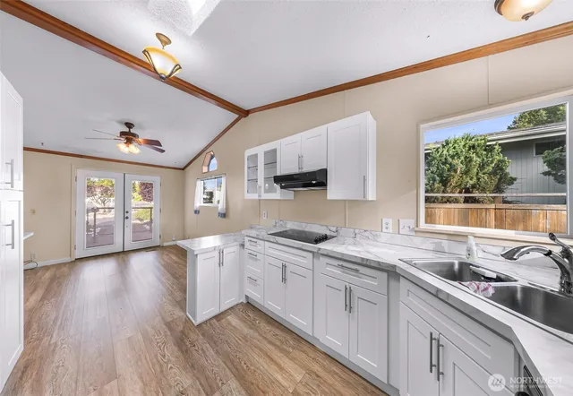 a kitchen with granite countertop a sink stainless steel appliances and cabinets