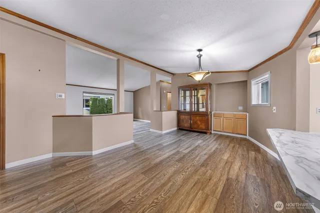 a view of a big room with wooden floor windows and kitchen view