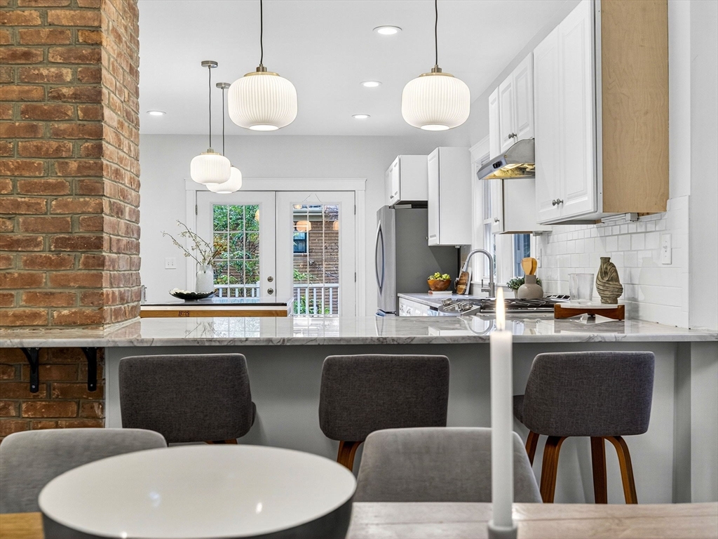 47 Roslin Street, Unit ONE Boston, MA 02124 - Photo 14 of 34 a kitchen with a table chairs sink and cabinets